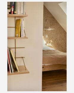 Regal Gassien Paris aus Holz und Messing in une chambre cosy aux tons Naturls chauds.