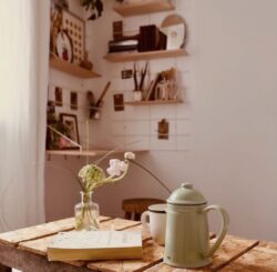 Chambre cosy Gassien Paris mit Regale Holz, carafe verte und Blumen délicates sur table brute.