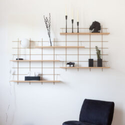 Modulare Regale Gassien Paris aus Holz und Messing in une chambre minimalistisch épurée.
