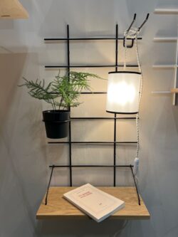 Table de nuit Gassien Paris en schwarzem Mundall und Holz mit lampe suspendue und Pflanze verte.