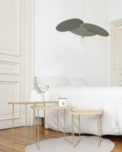 Chambre minimalistisch Gassien Paris mit tables gigognes Messing und Holz, Atmosphäre hell und épurée.