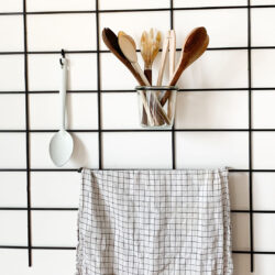 Küche minimalistisch Gassien Paris mit grille Wand noire, ustensiles Holz und torchon à carreaux.