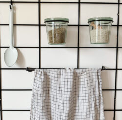 Küche minimalistisch Gassien Paris mit grille Wand noire, bocaux en verre und torchon à carreaux.