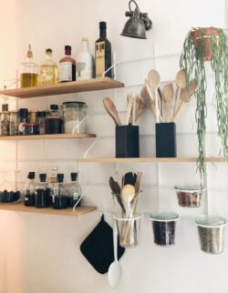 Küche organisée mit Regale aus Holz Gassien Paris, Mundall weiß, ustensiles und épices rangés élégamment.