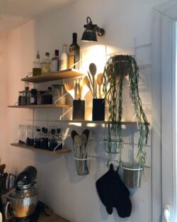 Küche organisée mit Regale Gassien Paris aus Holz und Mundall weiß, Pflanze, épices und ustensiles.