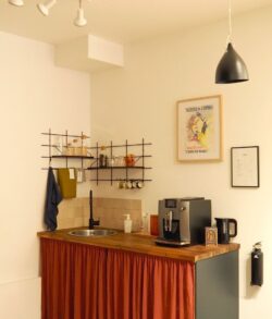 Küche minimalistisch mit Regal Gassien Paris en schwarzem Mundall, Atmosphäre café parisien chaleureuse.