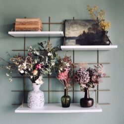 Regale Wands Messing Gassien Paris mit vases fleuris, Bücher anciens und peinture vintage, Atmosphäre végétale chic.