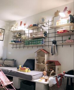 Kinderzimmer Gassien Paris mit Regale Holz und schwarzem Mundall, jouunds und Bücher colorés.