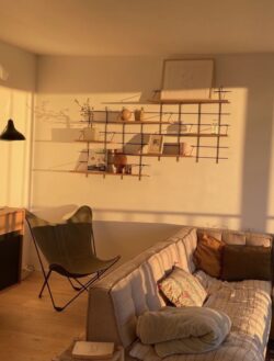 Wohnzimmer chaleureux Gassien Paris mit Modulare Regale aus Holz und schwarzem Mundall, lumière dorée.