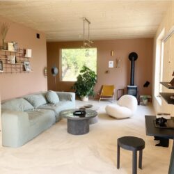 Wohnzimmer cosy aux murs rosés mit Regal Gassien Paris en schwarzem Mundall und Holz.