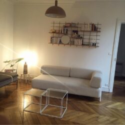 Helles Wohnzimmer mit Wandregal Gassien Paris en Messing und Holz, Atmosphäre minimalistisch chaleureuse.