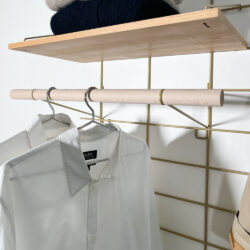 Aufbewahrungssystem Gassien Paris en Messing und Holz mit chemises weißs A.P.C. suspendues.